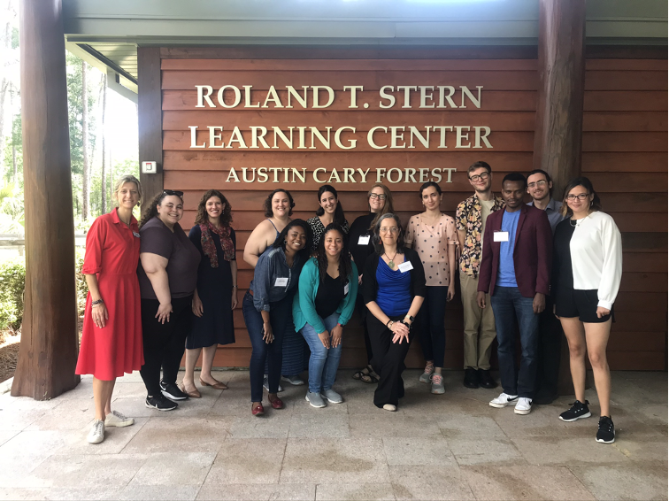 Group of 17 diverse people posing in front of a building with the text "ROLAND T. STERN LEARNING CENTER AUSTIN CARY FOREST".