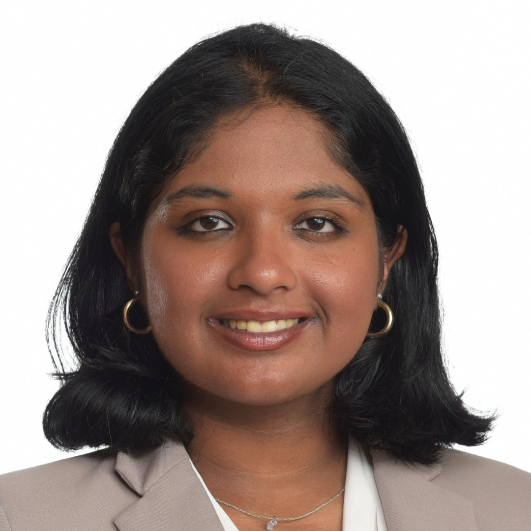 Professional headshot of a smiling woman with dark hair and a light blazer looking at the camera.