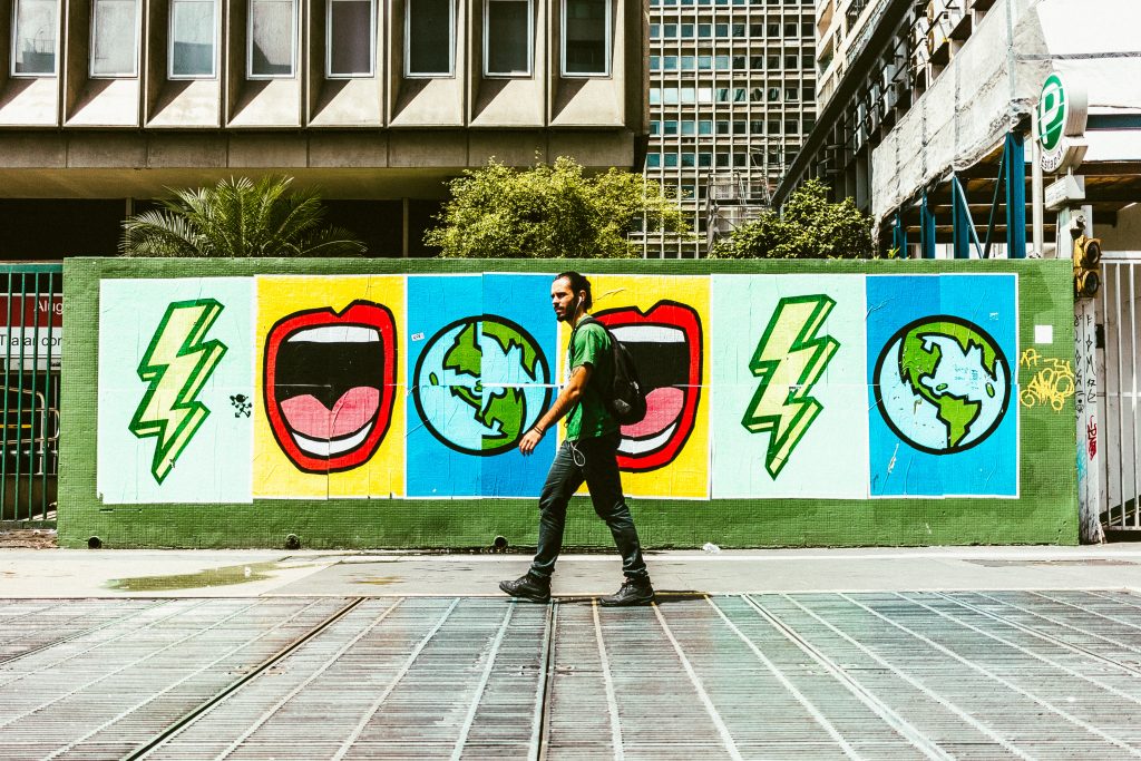 man walking in front of street art